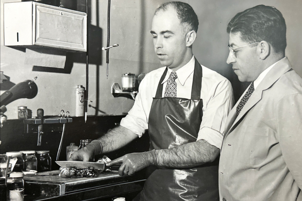 Dr. Culbertson Dissects a surgical specimen and selects a small representative piece of issue from which a slide will be made as Dr. Giordano advises, circa 1941 