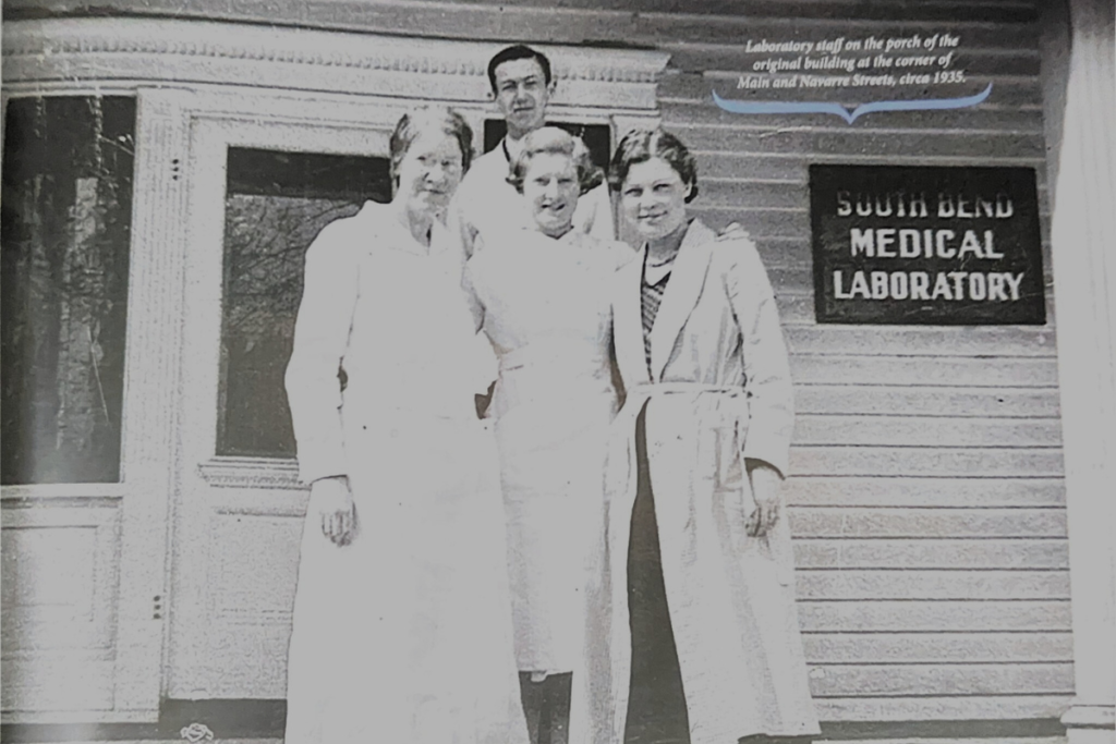 laboratory staff on the porch of the original building at the corner of Main and Navarre Streets, circa 1935